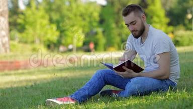 年轻人拿着日记坐在公园里